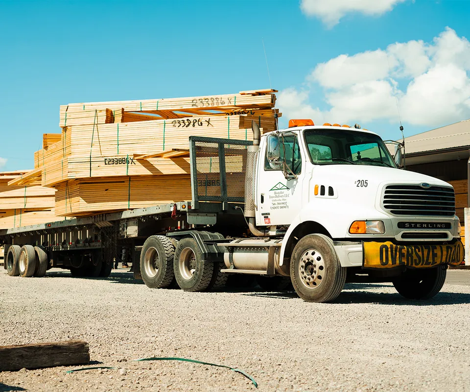 A large truck transporting a load of wooden trusses